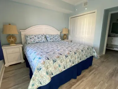 a bed in a bedroom with two night stands and two lamps at Celadon 207 beachfront 1 BR 2 BA Sleeps 6 in Panama City Beach