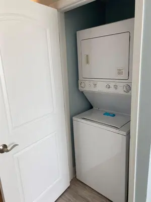 a washer and dryer in a bathroom with a door at Celadon 207 beachfront 1 BR 2 BA Sleeps 6 in Panama City Beach