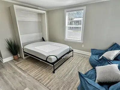 a room with a bed and a couch and a window at 13900 Millcole Ave - Beachy Bungalow - Sleeps 10 in Panama City Beach