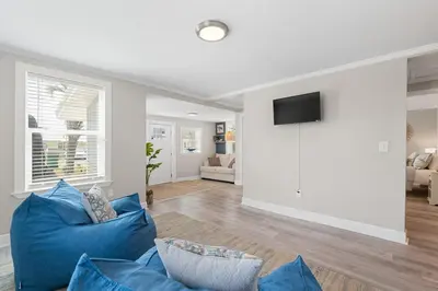 a living room with a blue couch and a tv at 13900 Millcole Ave - Beachy Bungalow - Sleeps 10 in Panama City Beach