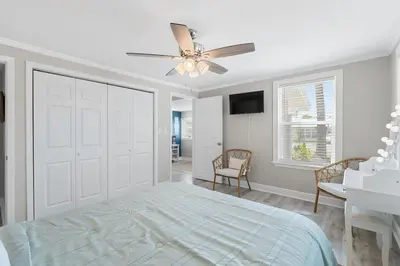 a bedroom with a bed and a ceiling fan at 13900 Millcole Ave - Beachy Bungalow - Sleeps 10 in Panama City Beach