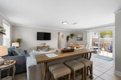 a living room with a table and a couch at 13900 Millcole Ave - Beachy Bungalow - Sleeps 10 in Panama City Beach
