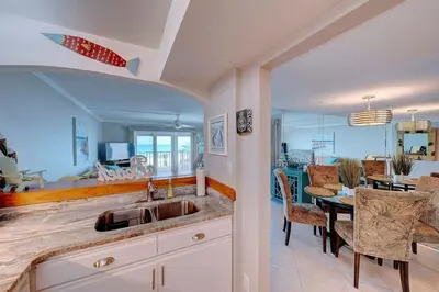 a kitchen with a sink and a dining room at Mariner East #201 1 BR 2 BA Amazing Balcony! in Panama City Beach