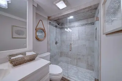 a bathroom with a toilet and a glass shower at Mariner East #201 1 BR 2 BA Amazing Balcony! in Panama City Beach