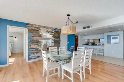 a dining room with a glass table and white chairs at Watercrest 1603 - 2 BR 2 BA Beachfront Balcony in Panama City Beach