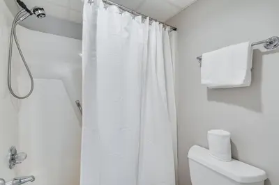 a bathroom with a white shower curtain and a toilet at Watercrest 1603 - 2 BR 2 BA Beachfront Balcony in Panama City Beach