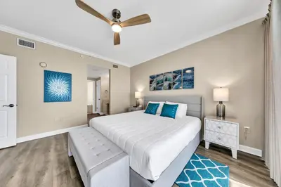 a bedroom with a large bed and a ceiling fan at Boardwalk 2101 in Panama City Beach