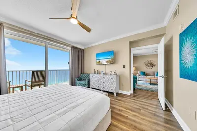 a bedroom with a bed and a view of the ocean at Boardwalk 2101 in Panama City Beach