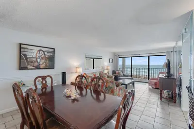 a dining room with a table and a living room at 5th Floor Oceanview Getaway - Moondrifter in Panama City Beach