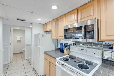 a kitchen with a stove and a refrigerator at 5th Floor Oceanview Getaway - Moondrifter in Panama City Beach
