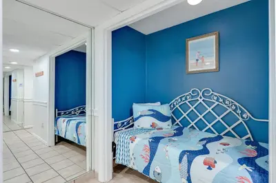 a bedroom with blue walls and a bed at 5th Floor Oceanview Getaway - Moondrifter in Panama City Beach