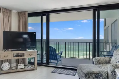 a living room with a television and a balcony at Watercrest 901 2 BR 2 BA sleeps 8 Amazing balcony! in Panama City Beach