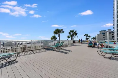 a boardwalk with chairs and the beach and the ocean at Watercrest 901 2 BR 2 BA sleeps 8 Amazing balcony! in Panama City Beach
