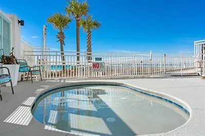 a swimming pool with palm trees and a fence at Watercrest 502 - Perfect Family Getaway 2BR 2 BA in Panama City Beach