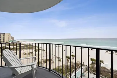 a white chair sitting on a balcony overlooking the beach at Watercrest 502 - Perfect Family Getaway 2BR 2 BA in Panama City Beach