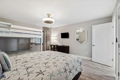 a bedroom with a large bed and a mirror at Watercrest 902 - Ocean Pearl Retreat - Renovated! in Panama City Beach