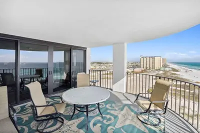 a balcony with a table and chairs and the ocean at Watercrest 902 - Ocean Pearl Retreat - Renovated! in Panama City Beach