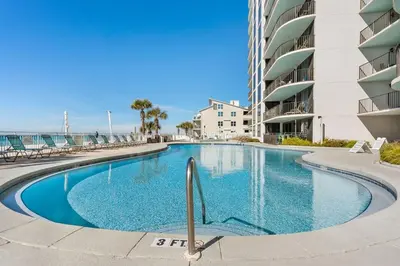 a swimming pool in front of a building at Watercrest 904 Beachfront 9th floor 3 BR 3 BA unit in Panama City Beach