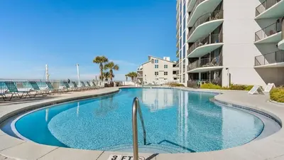 a swimming pool in front of a building at Watercrest 904 Beachfront 9th floor 3 BR 3 BA unit in Panama City Beach