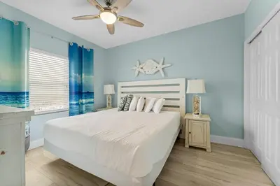 a bedroom with a bed and a ceiling fan at Family-Friendly Laketown Wharf Retreat Near Pineapple Willy’s & Beach in Panama City Beach