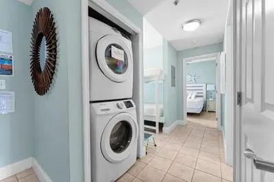 a washer and dryer in a room with a hallway at Family-Friendly Laketown Wharf Retreat Near Pineapple Willy’s & Beach in Panama City Beach