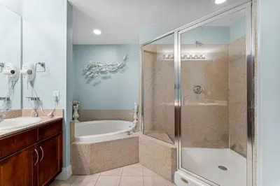 a bathroom with a shower and a tub and a sink at Family-Friendly Laketown Wharf Retreat Near Pineapple Willy’s & Beach in Panama City Beach