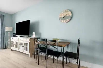 a dining room with a table and a clock on the wall at Family-Friendly Laketown Wharf Retreat Near Pineapple Willy’s & Beach in Panama City Beach