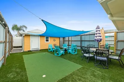 a patio with blue chairs and tables and a tent at Spacious Dog-Friendly Unit with Game Room & Private Yard, Walk to East PCB Beach in Panama City Beach
