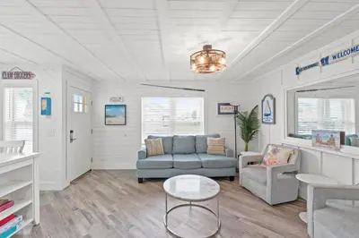 a living room with a couch and a table at Spacious Dog-Friendly Unit with Game Room & Private Yard, Walk to East PCB Beach in Panama City Beach