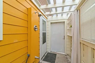 a yellow house with a yellow door and a window at Spacious Dog-Friendly Unit with Game Room & Private Yard, Walk to East PCB Beach in Panama City Beach