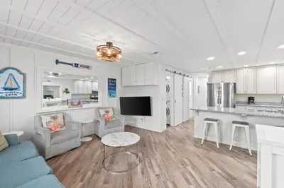 a living room with a couch and a table at Spacious Dog-Friendly Unit with Game Room & Private Yard, Walk to East PCB Beach in Panama City Beach