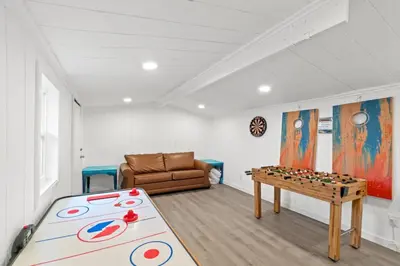 a living room with a table and a couch at Spacious Dog-Friendly Unit with Game Room & Private Yard, Walk to East PCB Beach in Panama City Beach