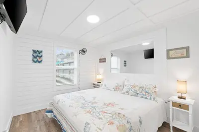 a white bedroom with a bed and a window at Spacious Dog-Friendly Duplex w/ Bonus Game Room & Private Backyard Near Beach in Panama City Beach