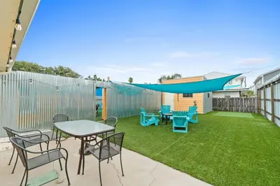 a backyard with a table and chairs and a blanket at Spacious Dog-Friendly Duplex w/ Bonus Game Room & Private Backyard Near Beach in Panama City Beach