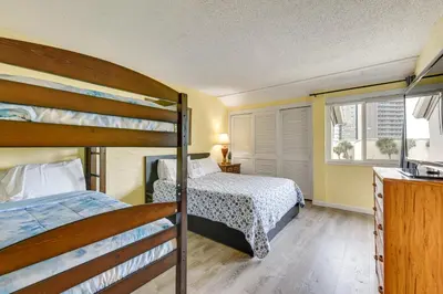a bedroom with two bunk beds and a window at Steps to Shore PCB Condo with Pool Access and Balcony in Panama City Beach