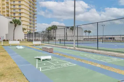 a tennis court with benches on a tennis court at Steps to Shore PCB Condo with Pool Access and Balcony in Panama City Beach
