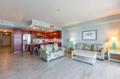 a living room with two couches and a kitchen at Laketown Wharf Condo beach view in Panama City Beach