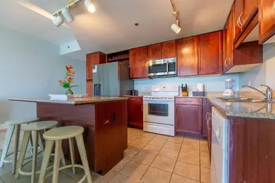 a kitchen with wooden cabinets and white appliances at Laketown Wharf Condo beach view in Panama City Beach