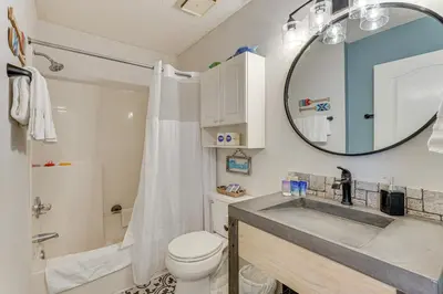 a bathroom with a sink and a toilet and a mirror at Walk to Beaches Resort Getaway Near Pier Park! in Panama City Beach