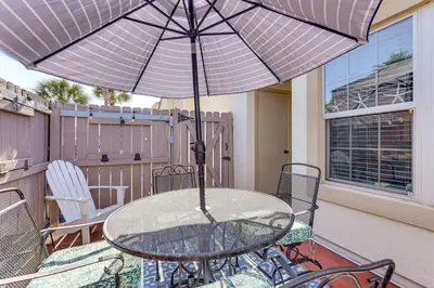 a glass table with an umbrella on a patio at Walk to Beaches Resort Getaway Near Pier Park! in Panama City Beach