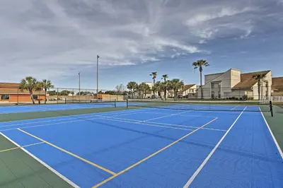 a tennis court with a blue tennis court at Walk to Beaches Resort Getaway Near Pier Park! in Panama City Beach