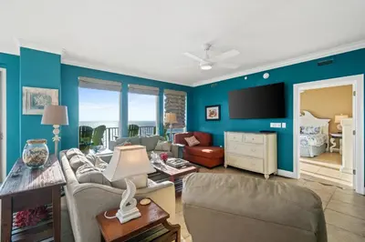 a living room with blue walls and a tv at Treasure Island #2101 in Panama City Beach