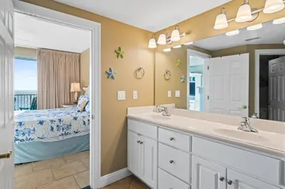 a bathroom with a sink and a bedroom with a bed at Treasure Island #2101 in Panama City Beach