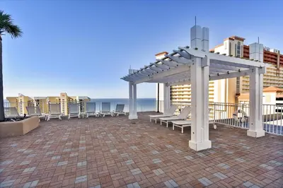 a deck with benches and a pergola overlooking the ocean at Laketown Wharf 338 condo in Panama City Beach