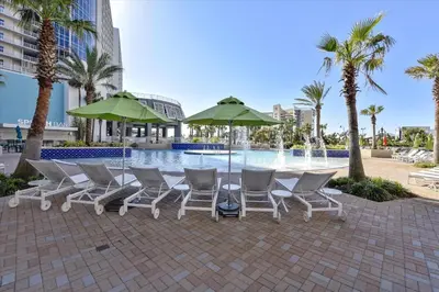 a group of chairs and umbrellas next to a pool at Laketown Wharf 338 condo in Panama City Beach