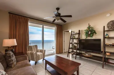 a living room with a couch and a television and a table at Splash Ocean-front Luxury Two-bedroom Beach Condo in Panama City Beach