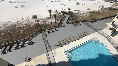 an overhead view of a swimming pool with chairs and a beach at Sunbird Resort 10th Floor Amazing Sunsets - by Sunbird Rentals in Panama City Beach