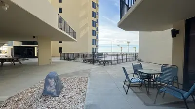 a patio with chairs and tables on a building at Sunbird Resort - First Floor - Free Beach Chairs by Sunbird Rentals in Panama City Beach