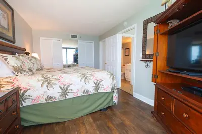 a bedroom with a bed and a flat screen tv at Sunbird Resort 11th Floor Free Beach Chairs - by Sunbird Rentals in Panama City Beach