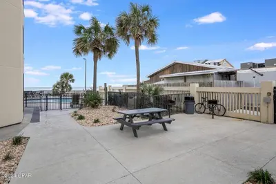 a bench sitting on a patio with palm trees at Sunbird Resort 11th Floor Free Beach Chairs - by Sunbird Rentals in Panama City Beach